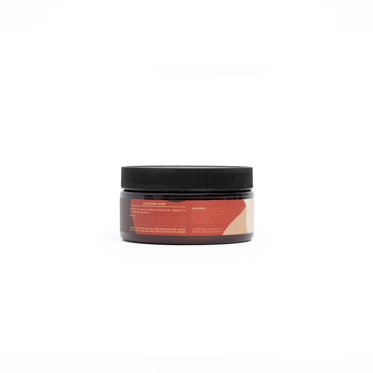 A brown plastic tin with a label contains As I Am CocoShea Whip. The product is a leave-in conditioner for curly hair and has a creamy consistency.