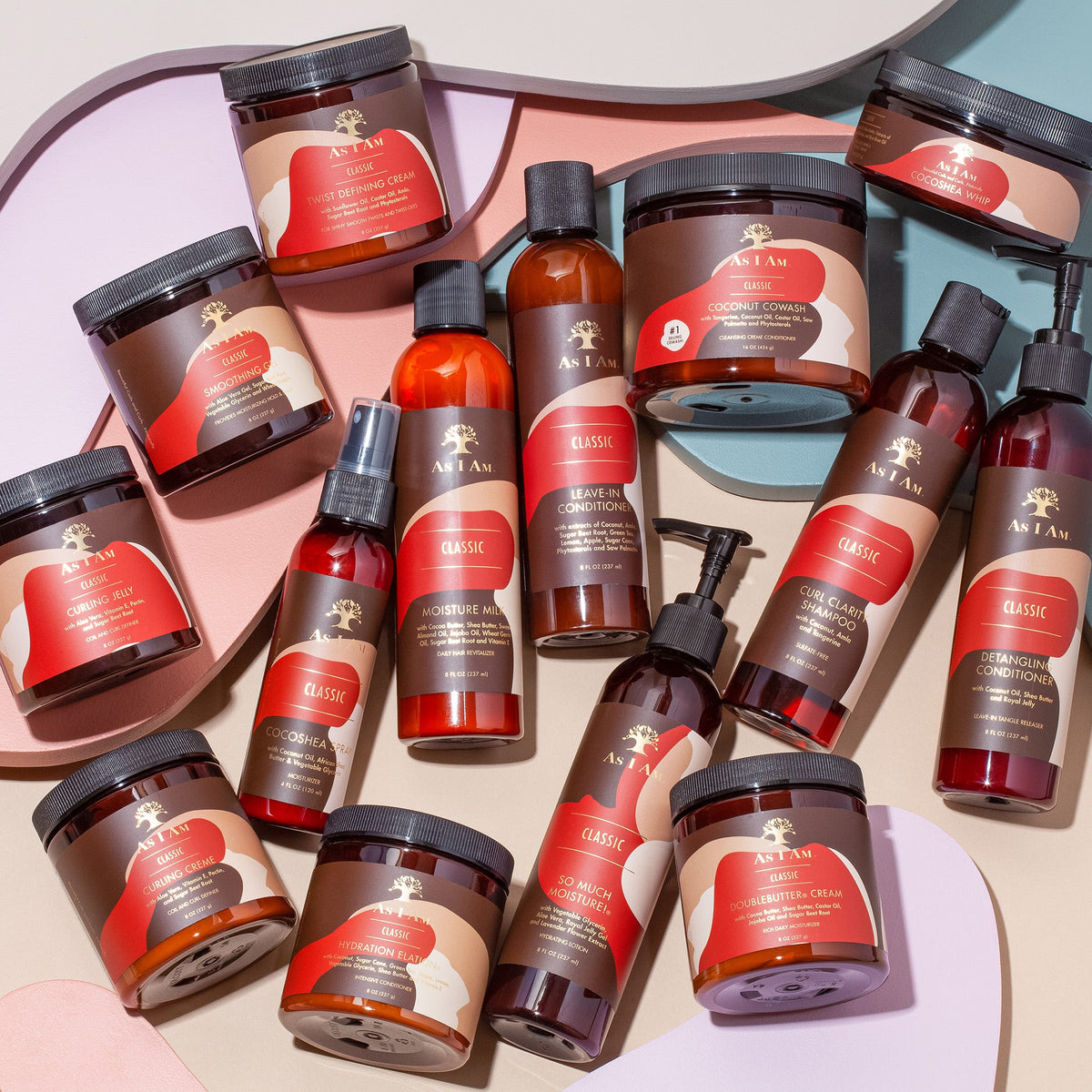 Different hair care products from As I Am on a colorful background. The products include bottles, jars and spray bottles in various sizes and shapes, all with the distinctive As I Am design.