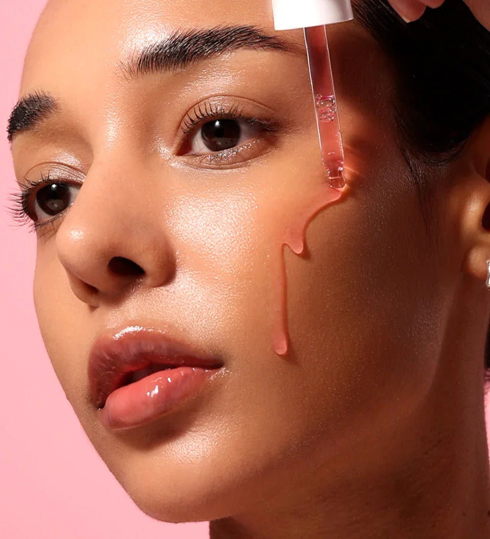Anua Niacinamide 10% + TXA 4% Dark Spot Correcting Serum 30ml is dripped onto the cheek of a woman with glowing skin tone.