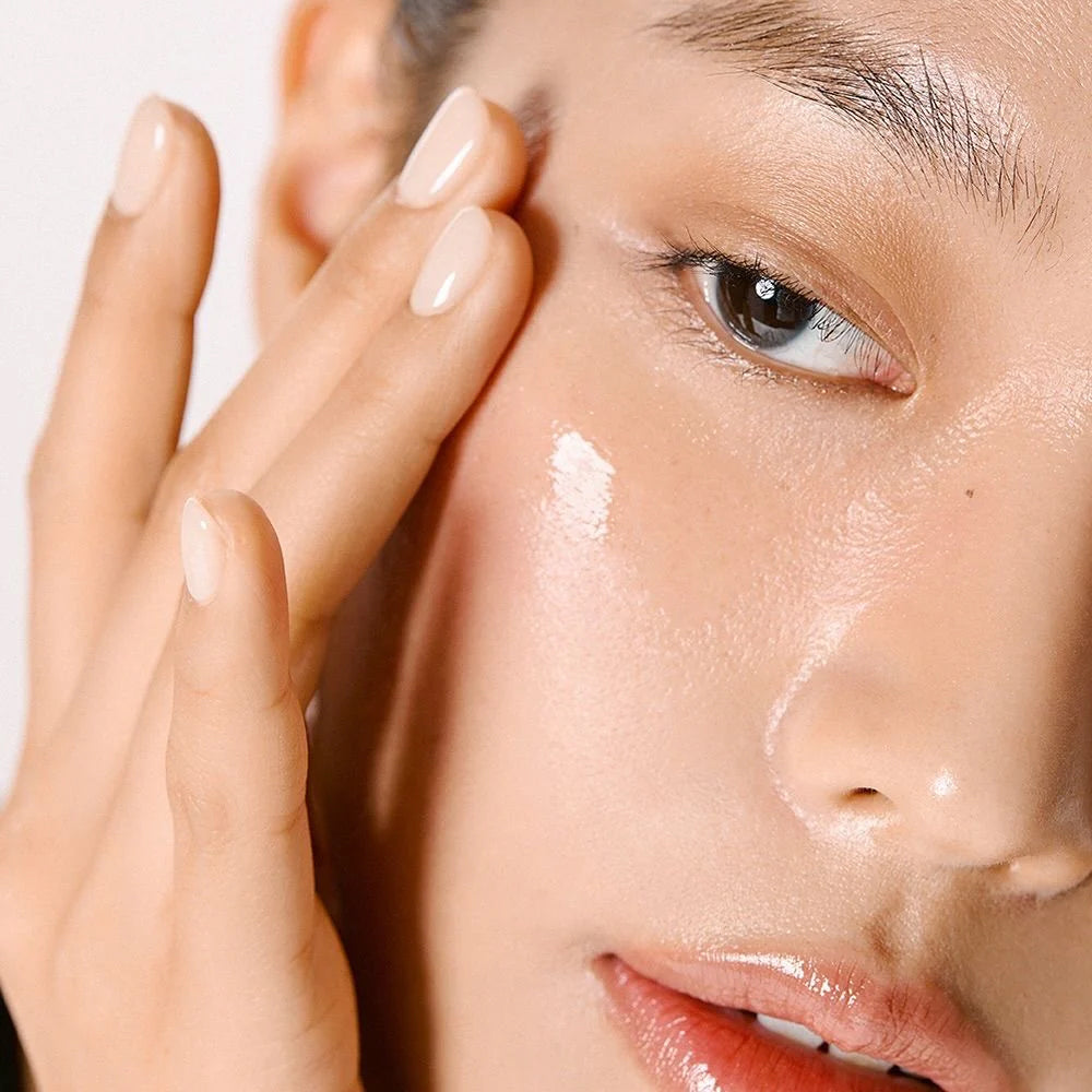 Finger applies Anua Niacinamide 10% + TXA 4% Dark Spot Correcting Serum 30ml to smooth, moisturized cheek.