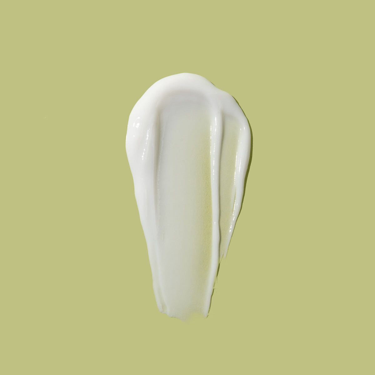 A dab of white As I Am Rosemary Conditioner on a light background showing the consistency of the product.