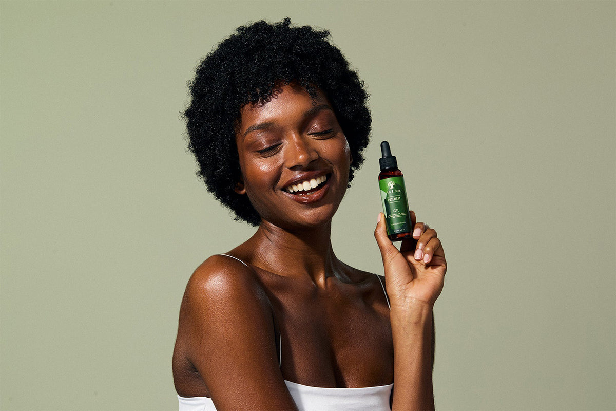 Women smiling and holding as i am rosemary oil in her hand.