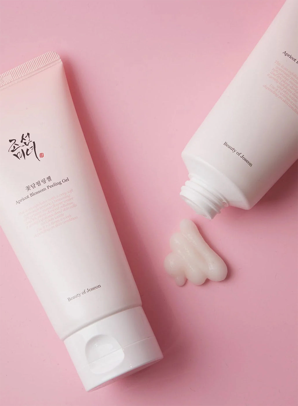 Tube of Beauty of Joseon Apricot Blossom Peeling Gel 100ml and gel on pink background.