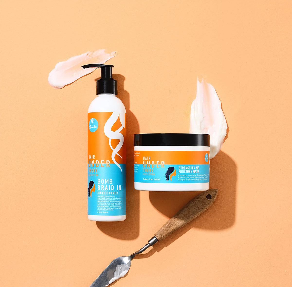 Curls Hair Under There Bomb Braid In Conditioner and Strengthen Me Moisture Mask on orange background with product samples and spatula. 
