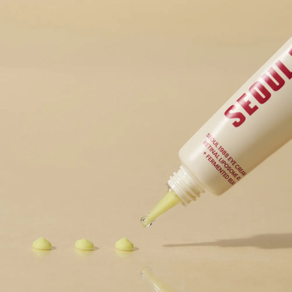 Light yellow K-Secret Eye Cream: Retinal Liposome 4% + Fermented Bean 30 ml is dosed in drops on a beige background.