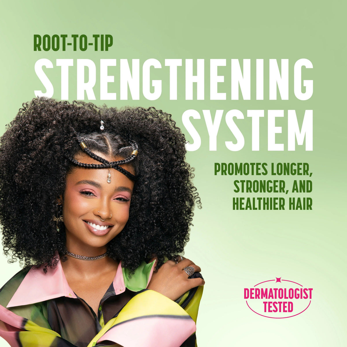 Smilende kvinde med afro-krøller og flettet hårbånd, reklame for Root-to-Tip Strengthening System hårplejeserie.