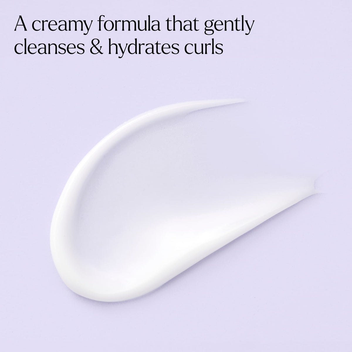 Cremet hvid shampoo-tekstur der renser og hydrerer krøller, mod lyslilla baggrund.